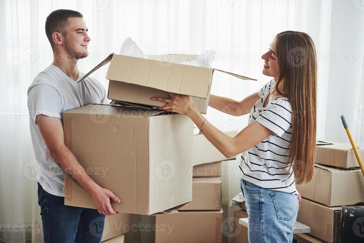 A lot of boxes. Cheerful young couple in their new apartment. Conception of moving photo