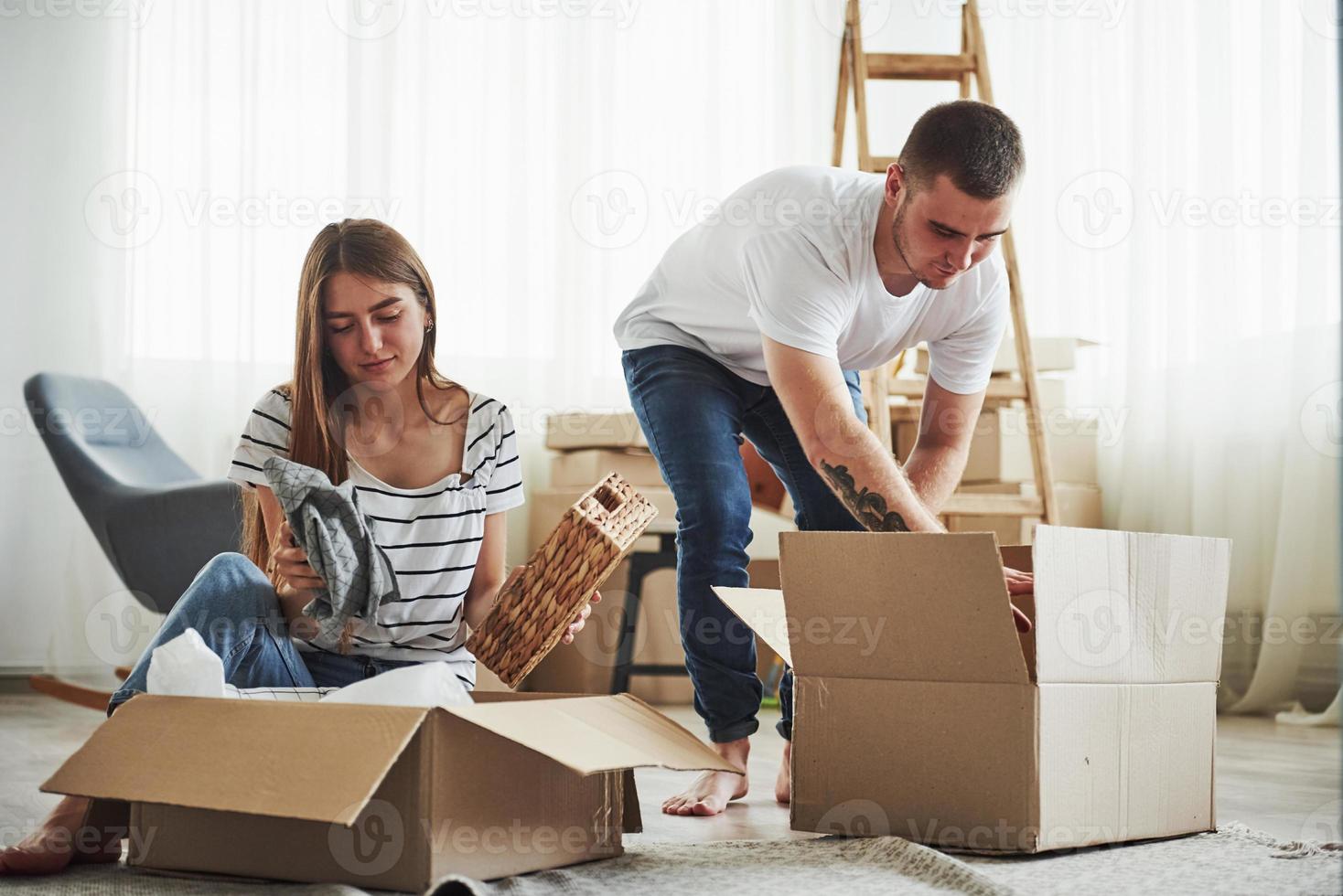 hora de desempacar esas cajas. pareja joven alegre en su nuevo apartamento. concepción de movimiento foto