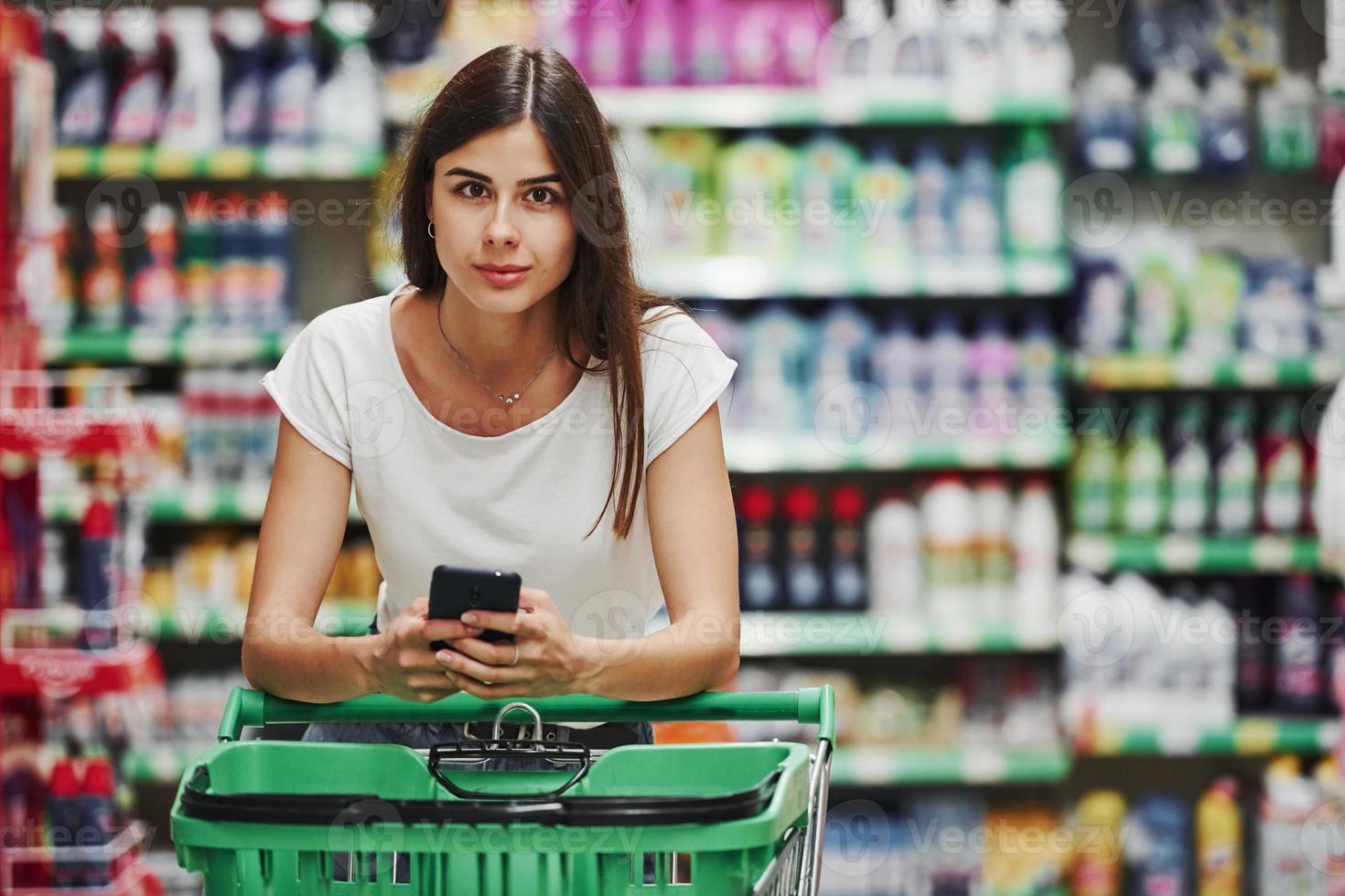 Female shopper in casual clothes in market looking for products photo