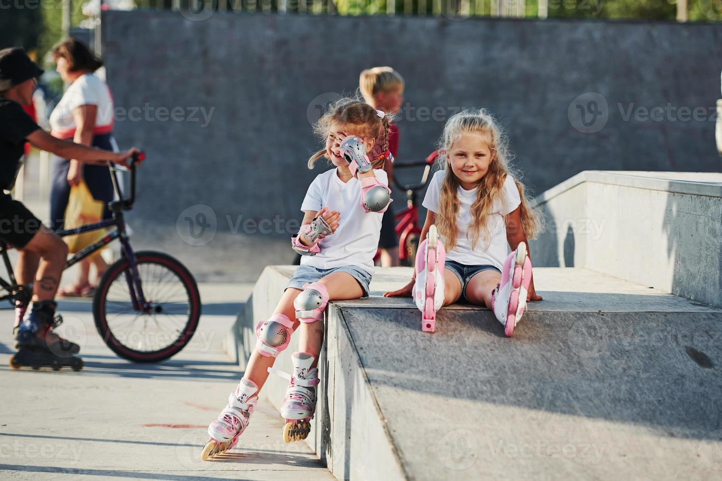 On the ramp for extreme sports. Two little girls with roller skates outdoors have fun photo