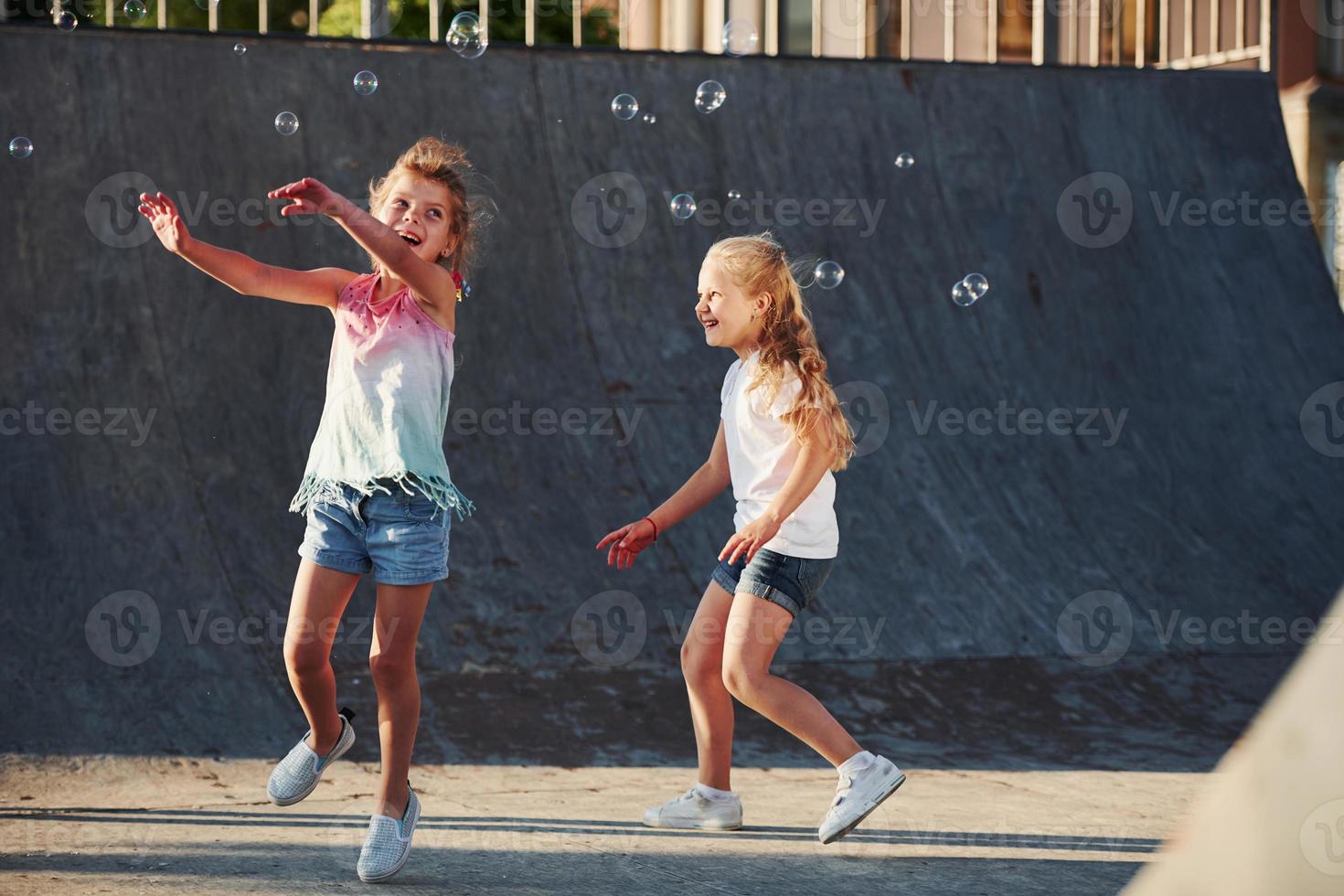 Having fun with bubbles. Leisure activities. Two little girls having fun in the park photo