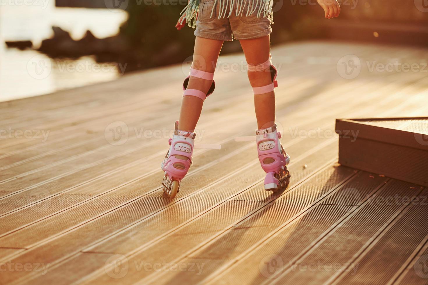 Particle view. Kid riding on her roller skates. Unbelievable sunlight photo