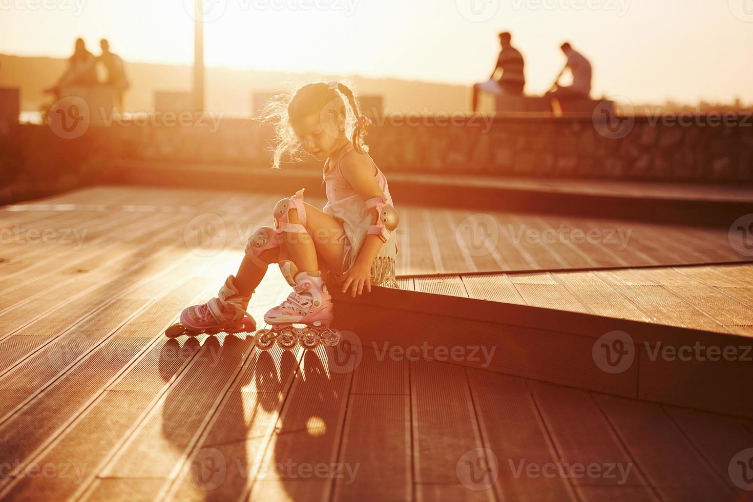 Happy cute kid with her roller skates. Unbelievable sunlight photo