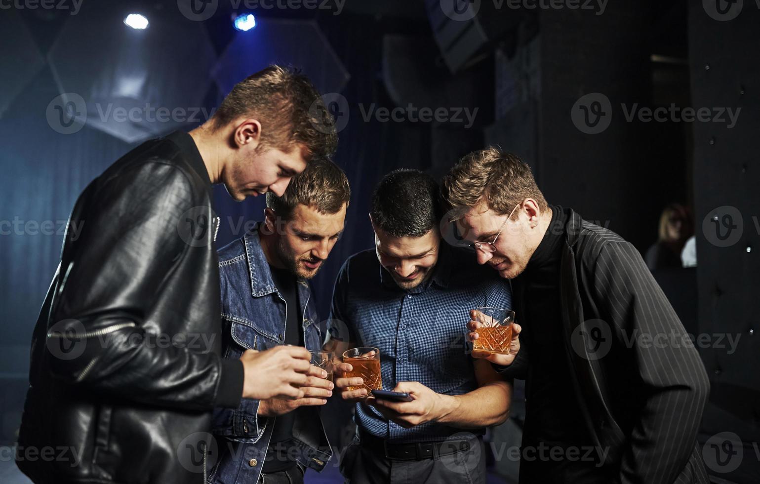 Weekend time spending. People have fun in the club. With alcohol in hands photo