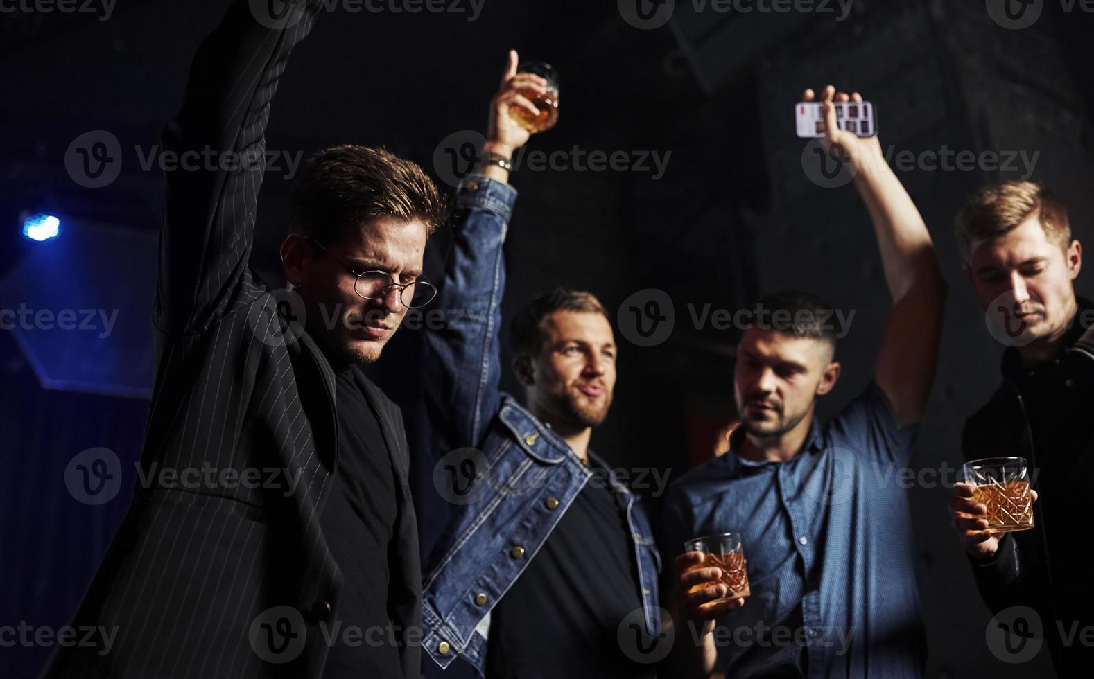 People have fun in the night club. With alcohol in hands photo