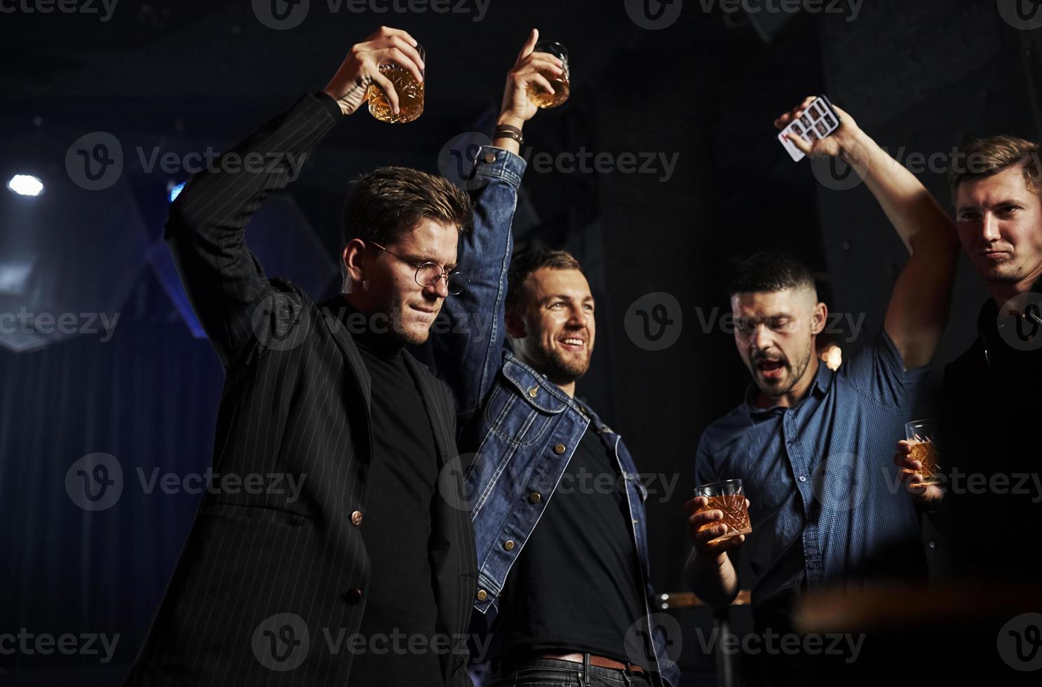 People have fun in the night club. With alcohol in hands photo