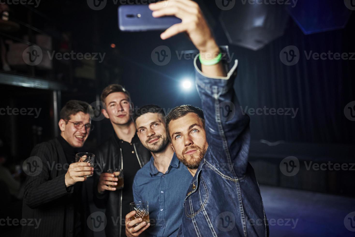 People have fun in the night club. With alcohol in hands photo