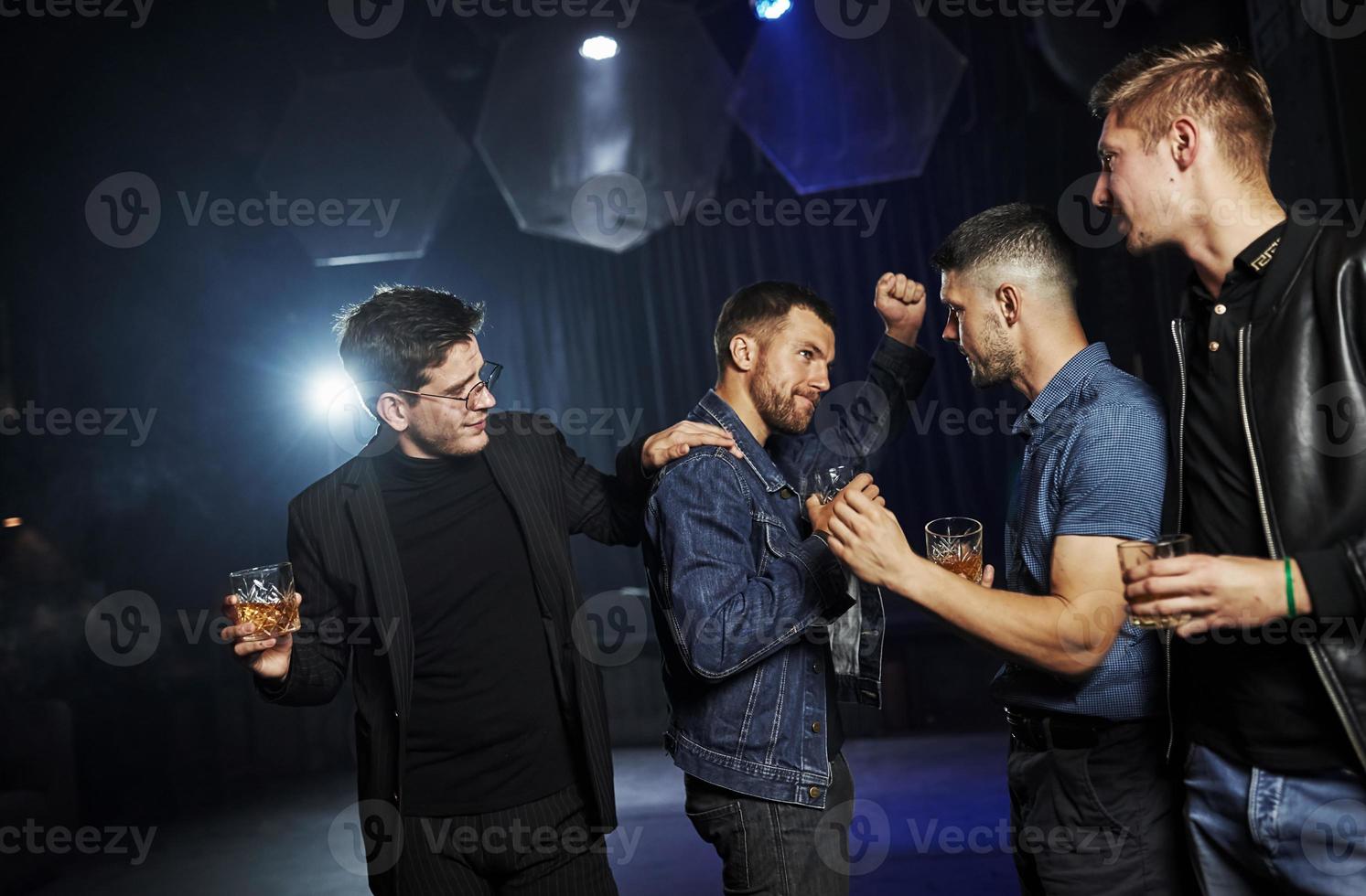 People have fun in the night club. With alcohol in hands photo