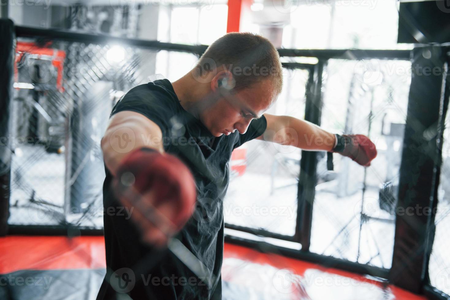 Taking a break. Sportsman at boxing ring have exercise. Leaning on the fence photo
