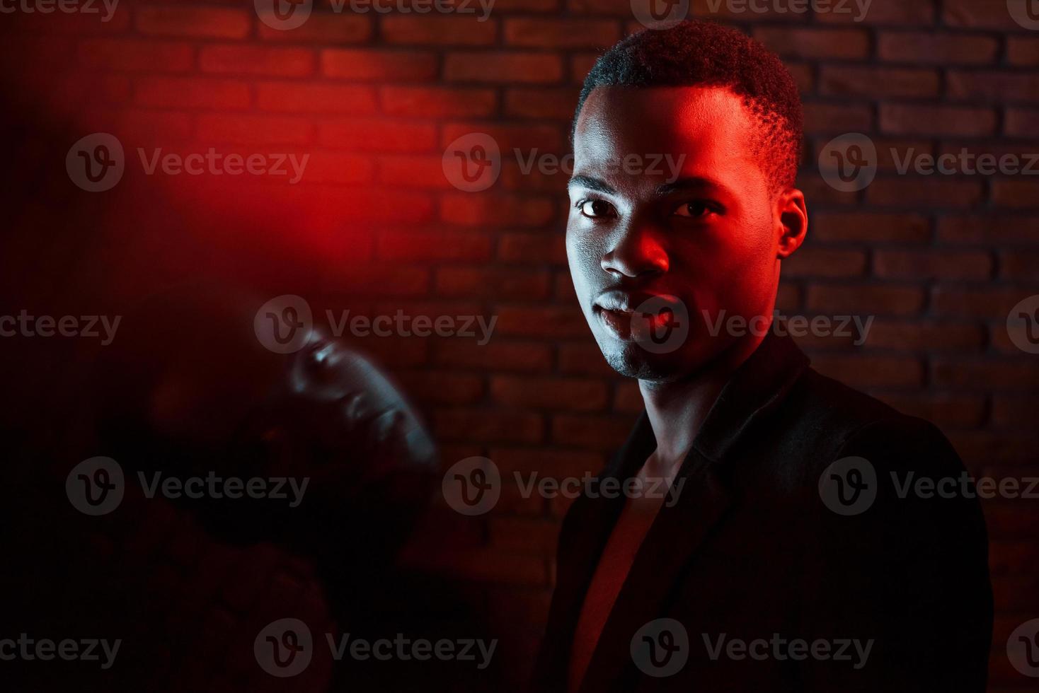 Beautiful reflection. Futuristic neon lighting. Young african american man in the studio photo