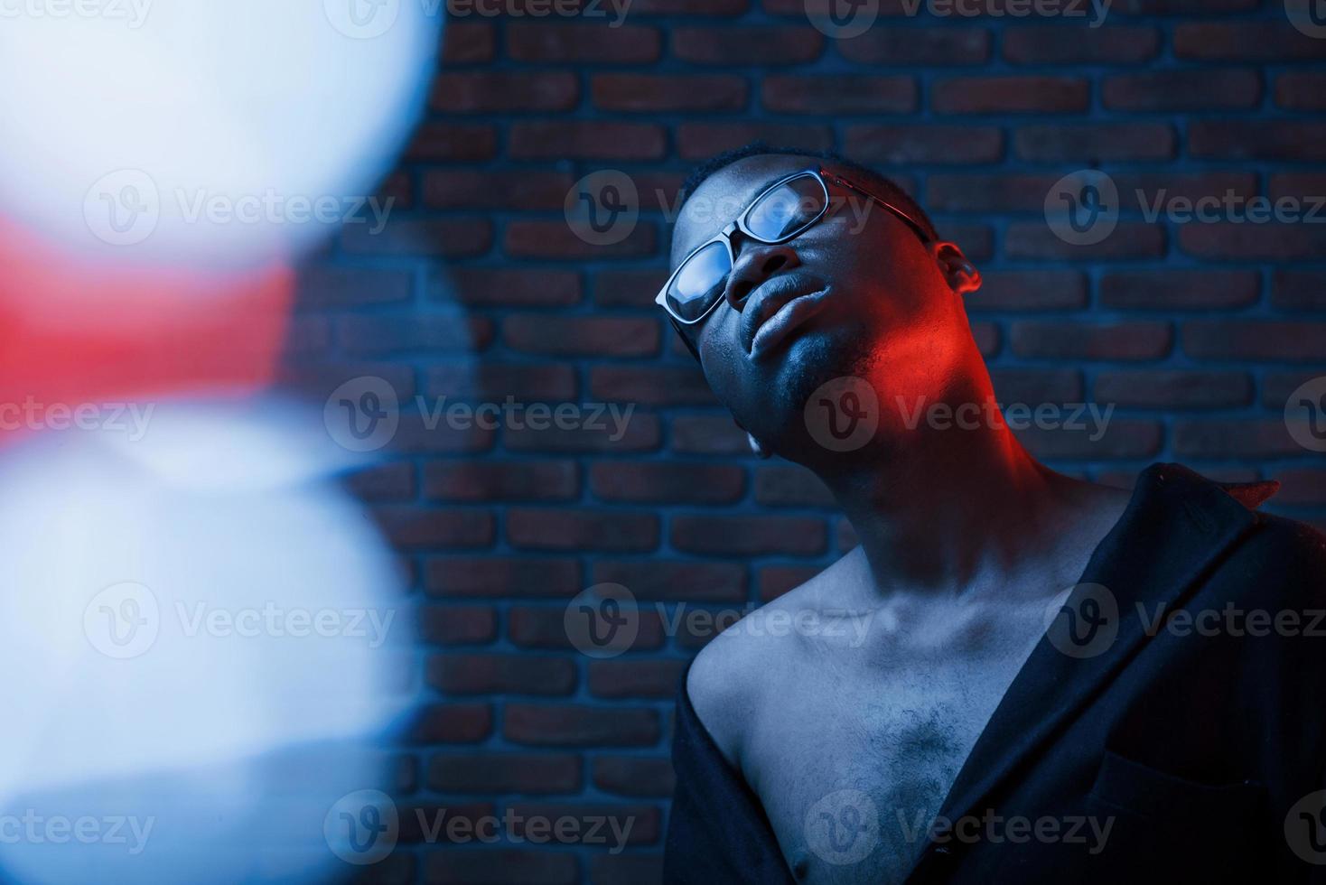 Light blinks. Futuristic neon. Young african american man in the studio photo