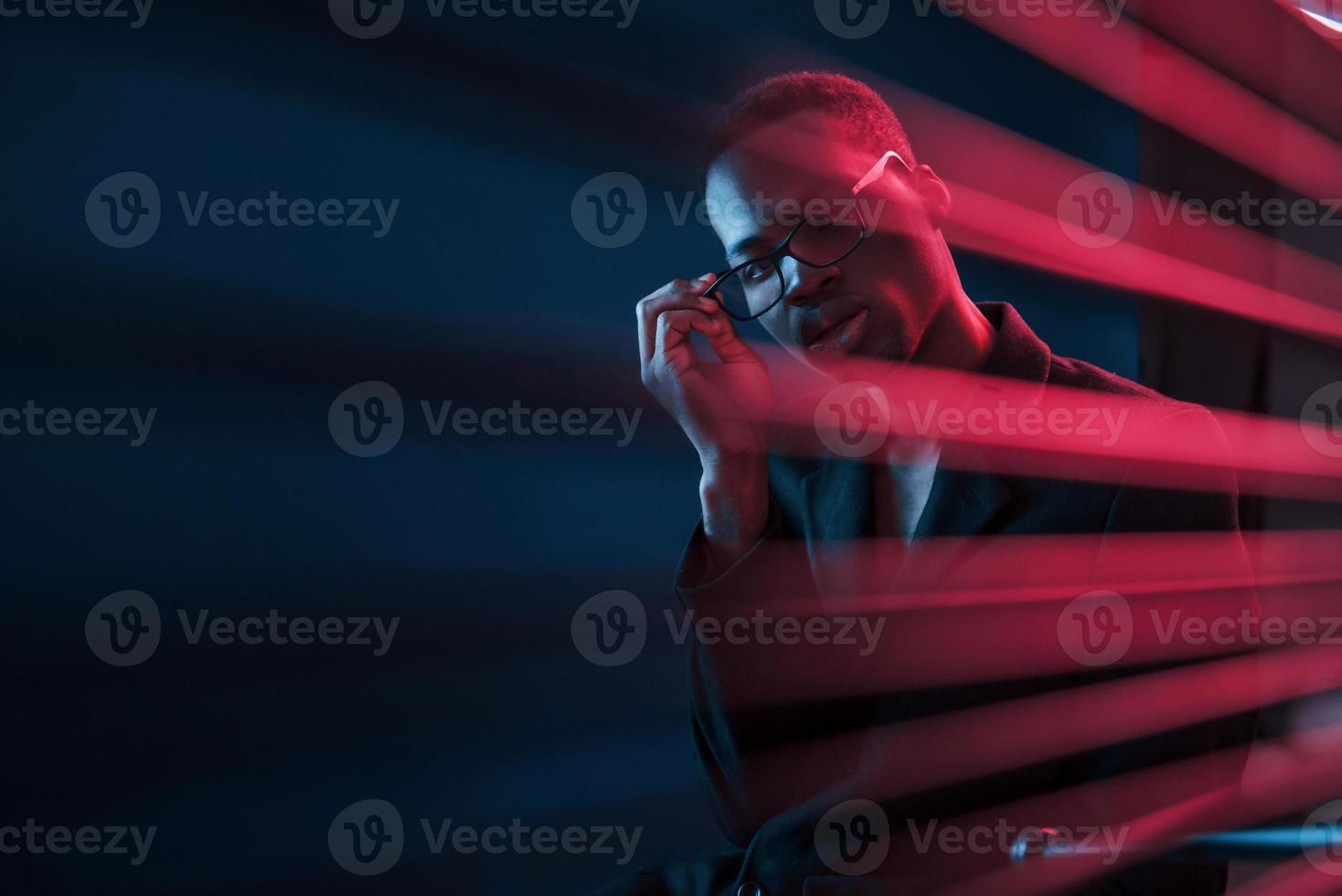 Interesting beams. Futuristic neon lighting. Young african american man in the studio photo