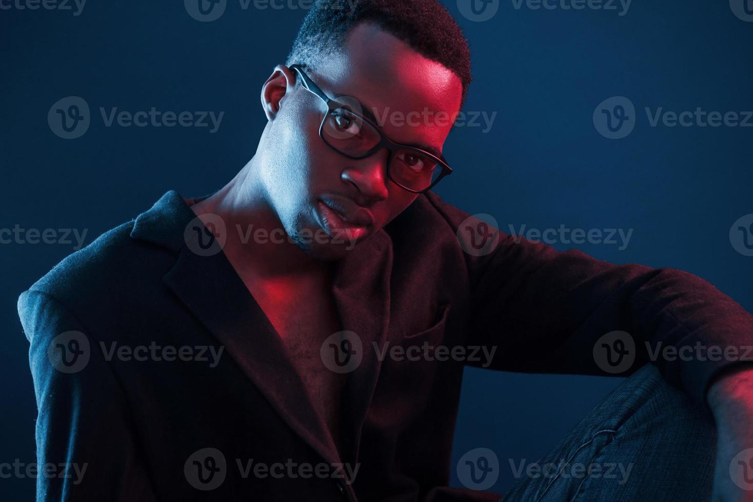 Fashion model. Futuristic neon lighting. Young african american man in the studio photo