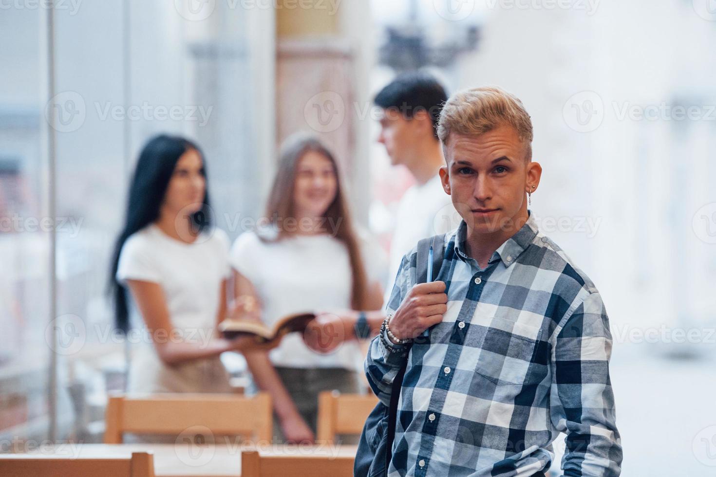 Four young students in casual clothes have meeting at rainy day photo