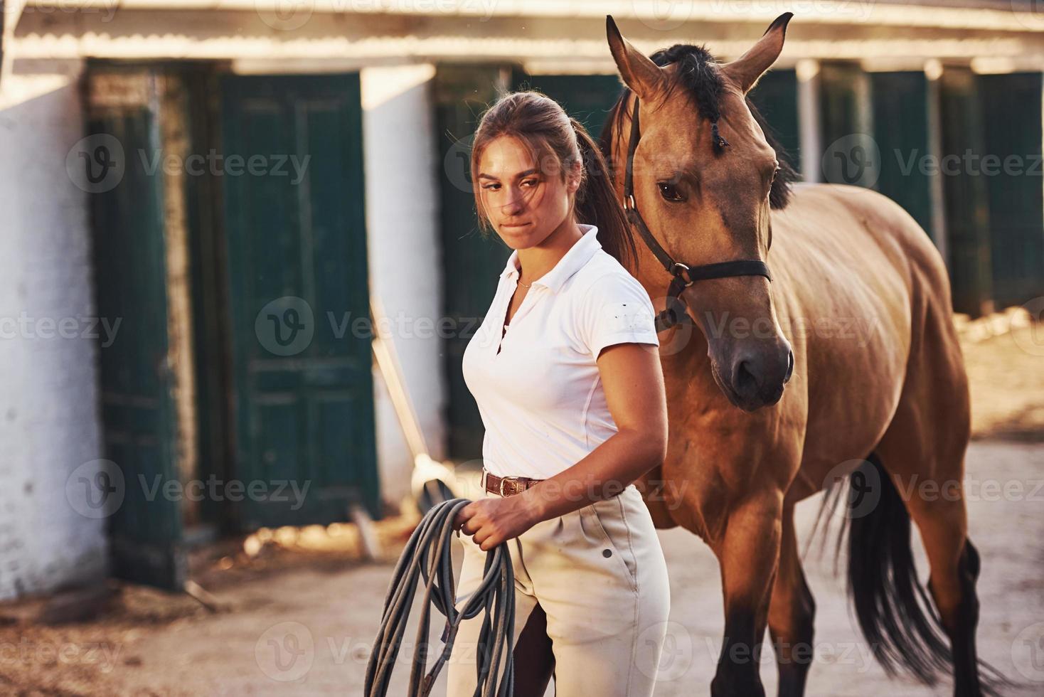 Getting ready for the ride. Horsewoman in white uniform with her horse at farm. Ready for the ride photo