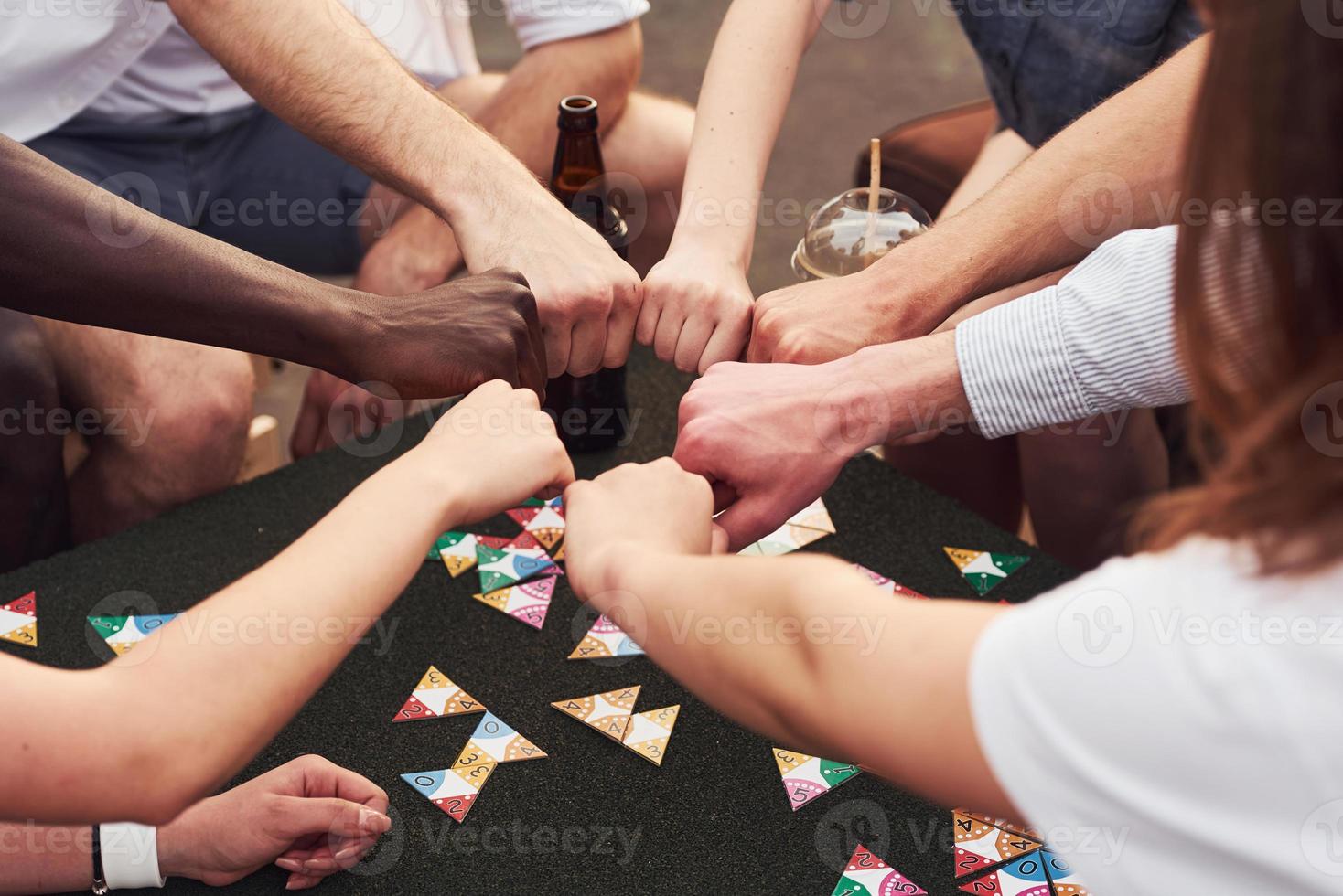 unidad de la gente. un grupo de jóvenes con ropa informal tienen una fiesta en la azotea juntos durante el día foto