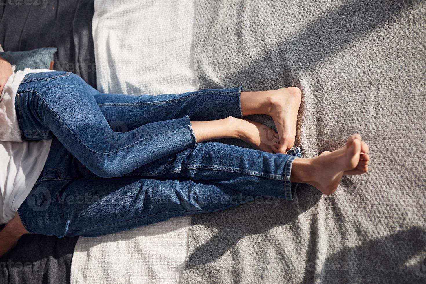 Close up view of young couple's legs on the bed at daytime photo
