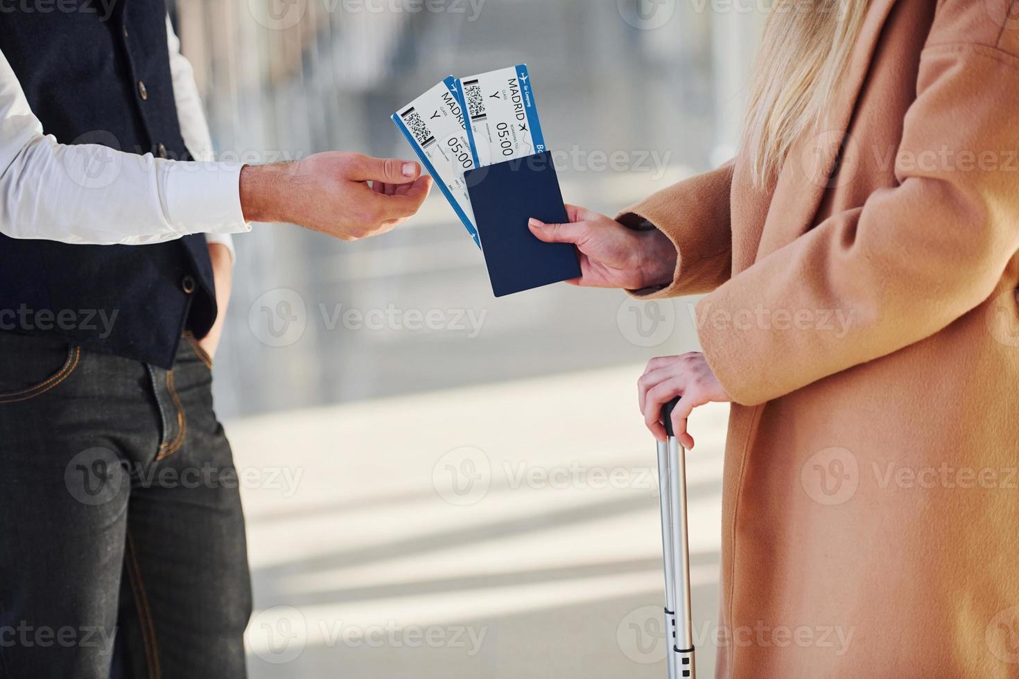 Close up view of woman that gives tickets to security man in airport photo