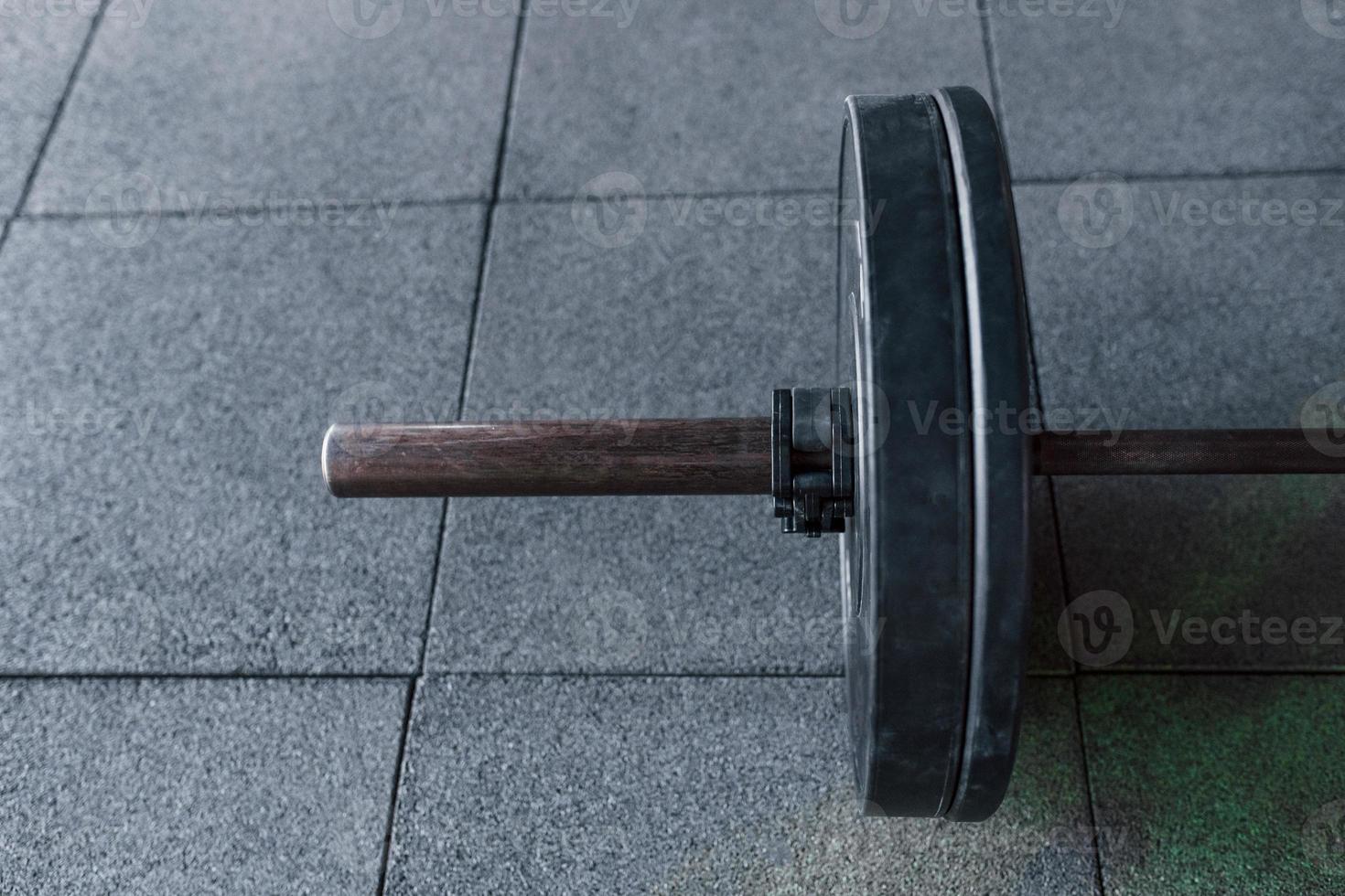 Close up view of barbell that lying down on the ground in modern gym photo