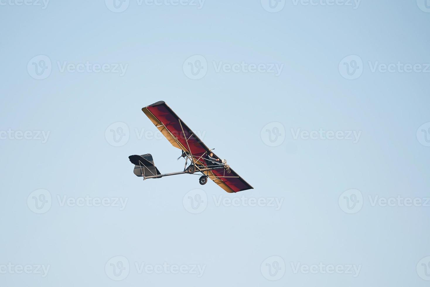 Plane flying high up in the cloudless sky at daytime. Male pilot photo