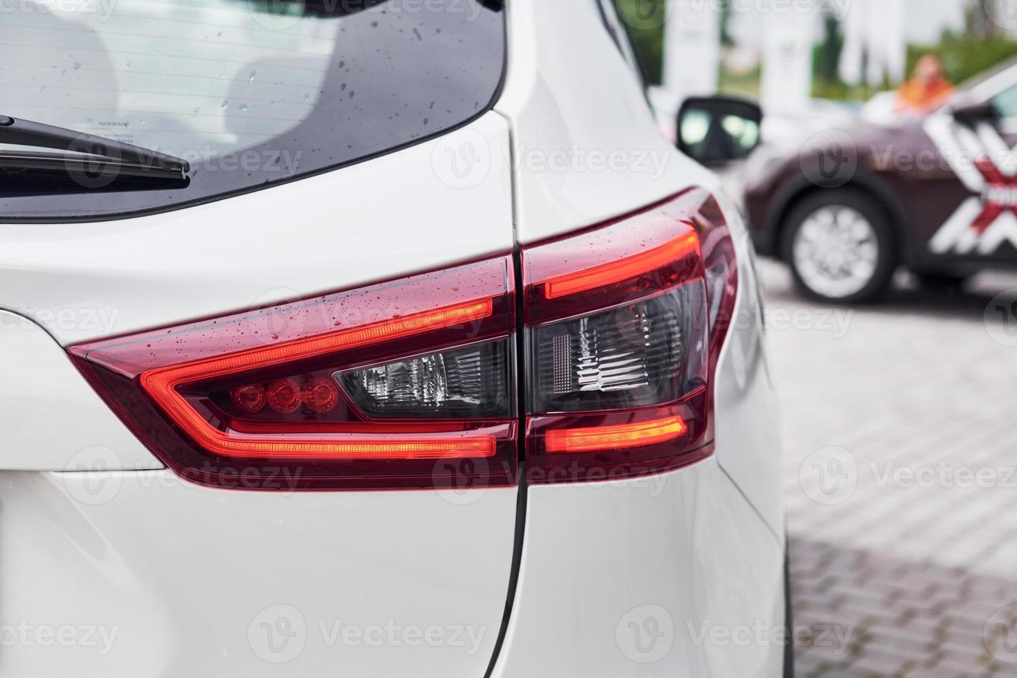 Rear particle view of modern white automobile. Close up view of headlights photo