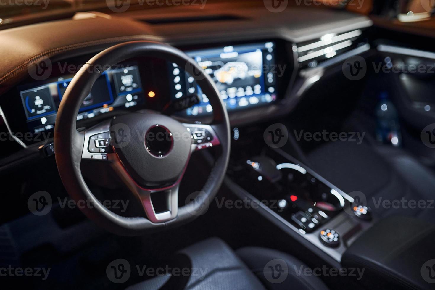 Steering wheel and navigation display. Close up view of front park of new modern black automobile photo