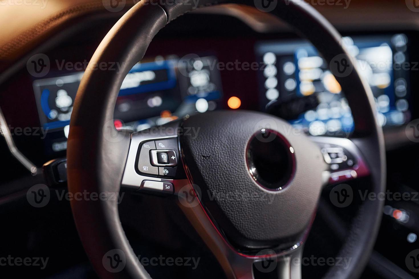 Steering wheel and navigation display. Close up view of front park of new modern black automobile photo