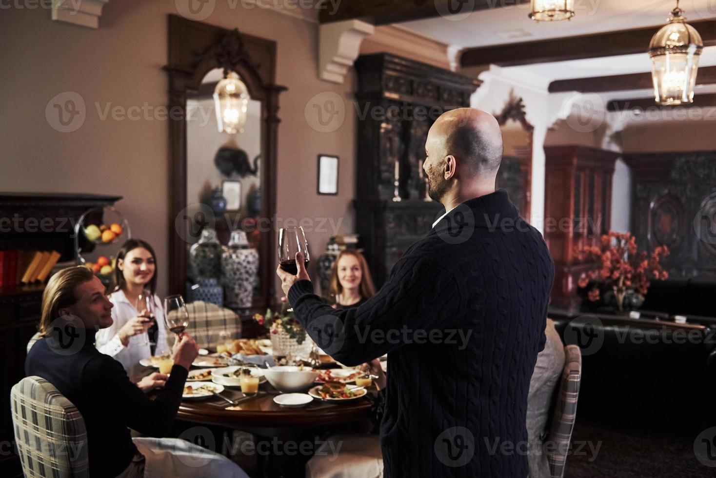 Listen to me please. Family friends having nice time in beautiful luxury modern restaurant photo