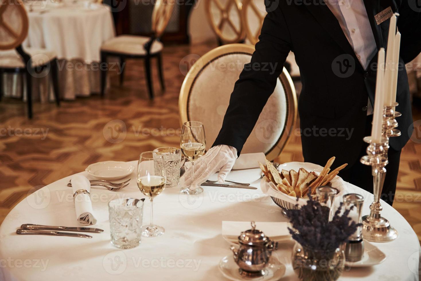 Professional waiter preparing the table in the vintage style luxure restaurant photo