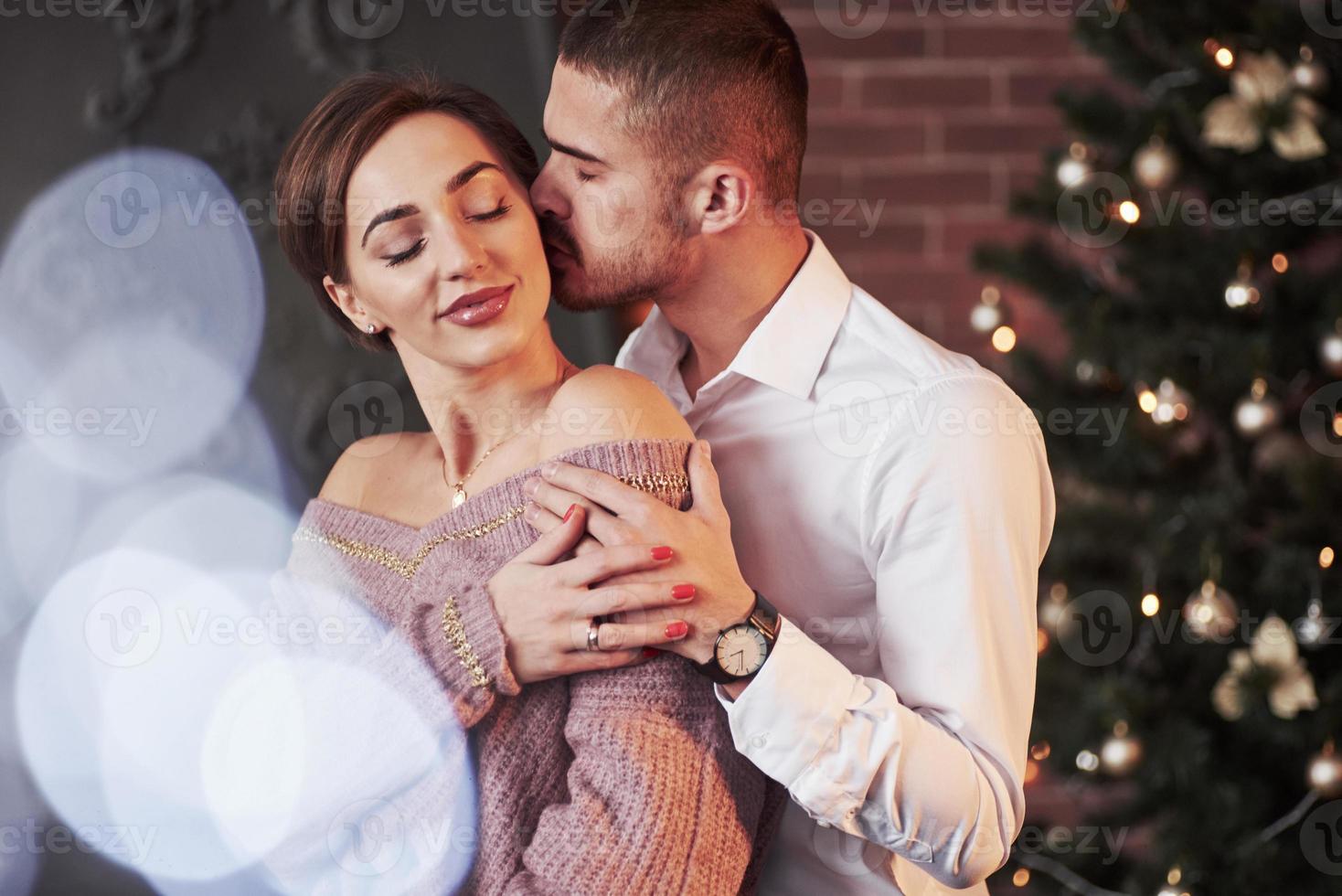 velada mágica juntos. una pareja agradable celebrando el año nuevo en el interior con ropa hermosa clásica sobre ellos foto