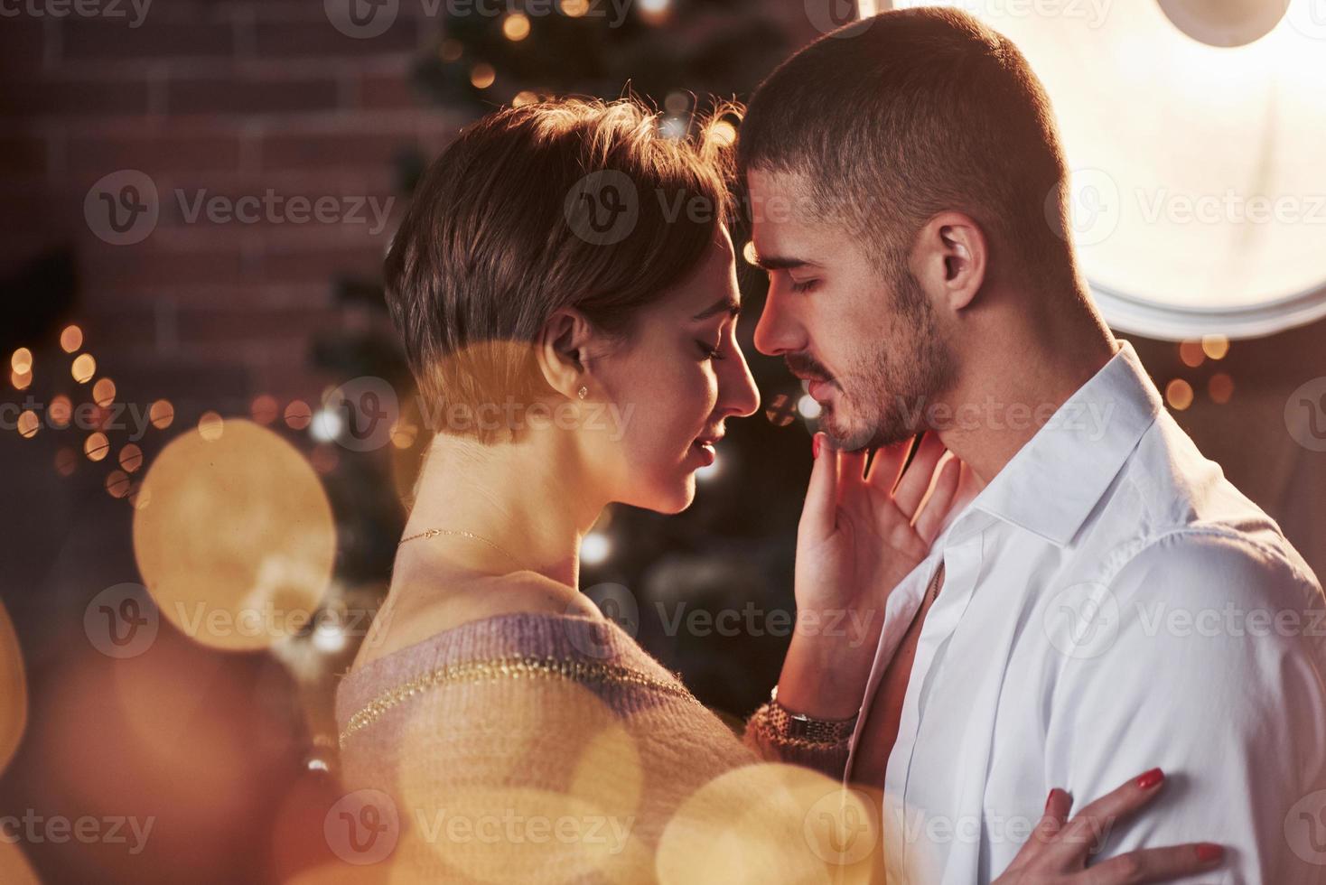 Awesome professional artificial lighting. Nice couple celebrating new year indoors with classic beautiful clothes on them photo