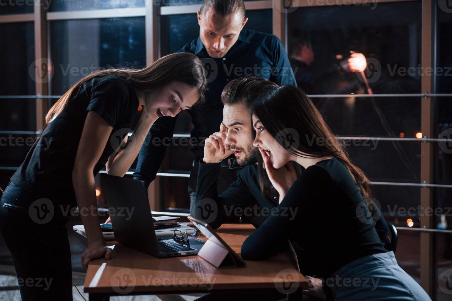 no tengo palabras equipo de jóvenes empresarios trabaja en su proyecto por la noche en la oficina foto