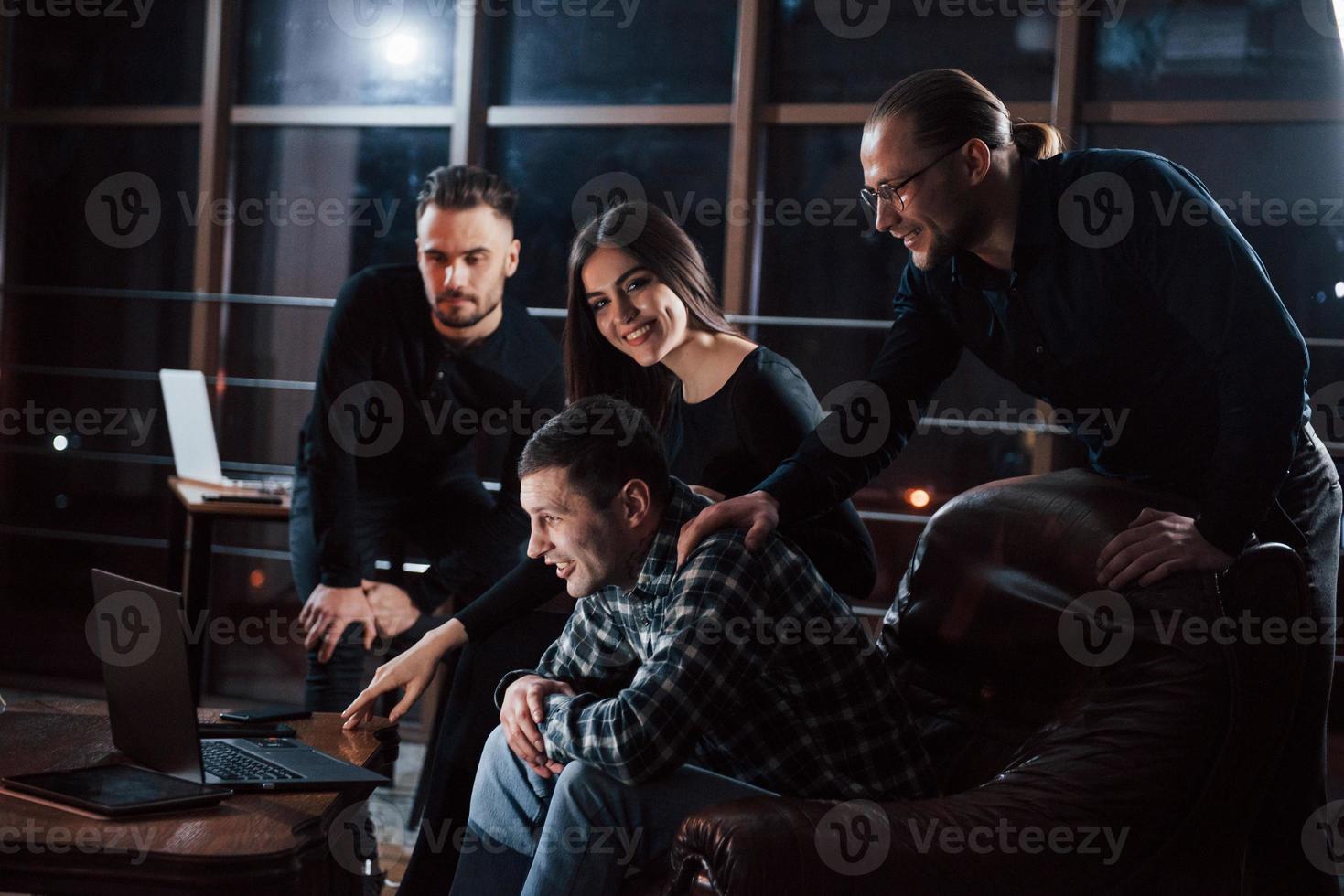 Life is great after successful job. Team of young business people works on their project at night time in the office photo