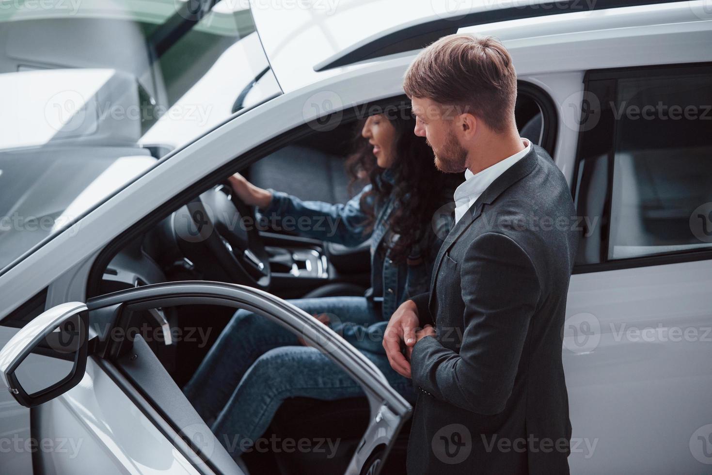 Any questions. Female customer and modern stylish bearded businessman in the automobile saloon photo