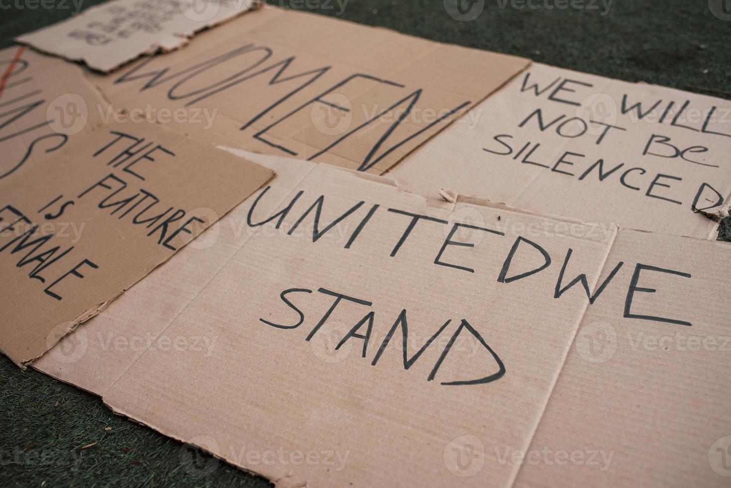 Woman rights. Group of banners with different feminist quotes lying on the ground photo