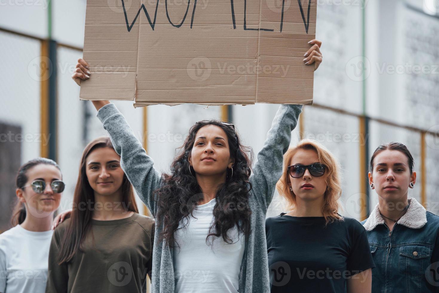con un letrero en las manos. grupo de mujeres feministas tienen protesta por sus derechos al aire libre foto
