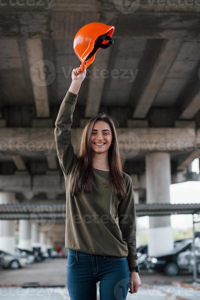 Say hello. Portrait of beautiful young woman with safety helmet standing under the bridge photo