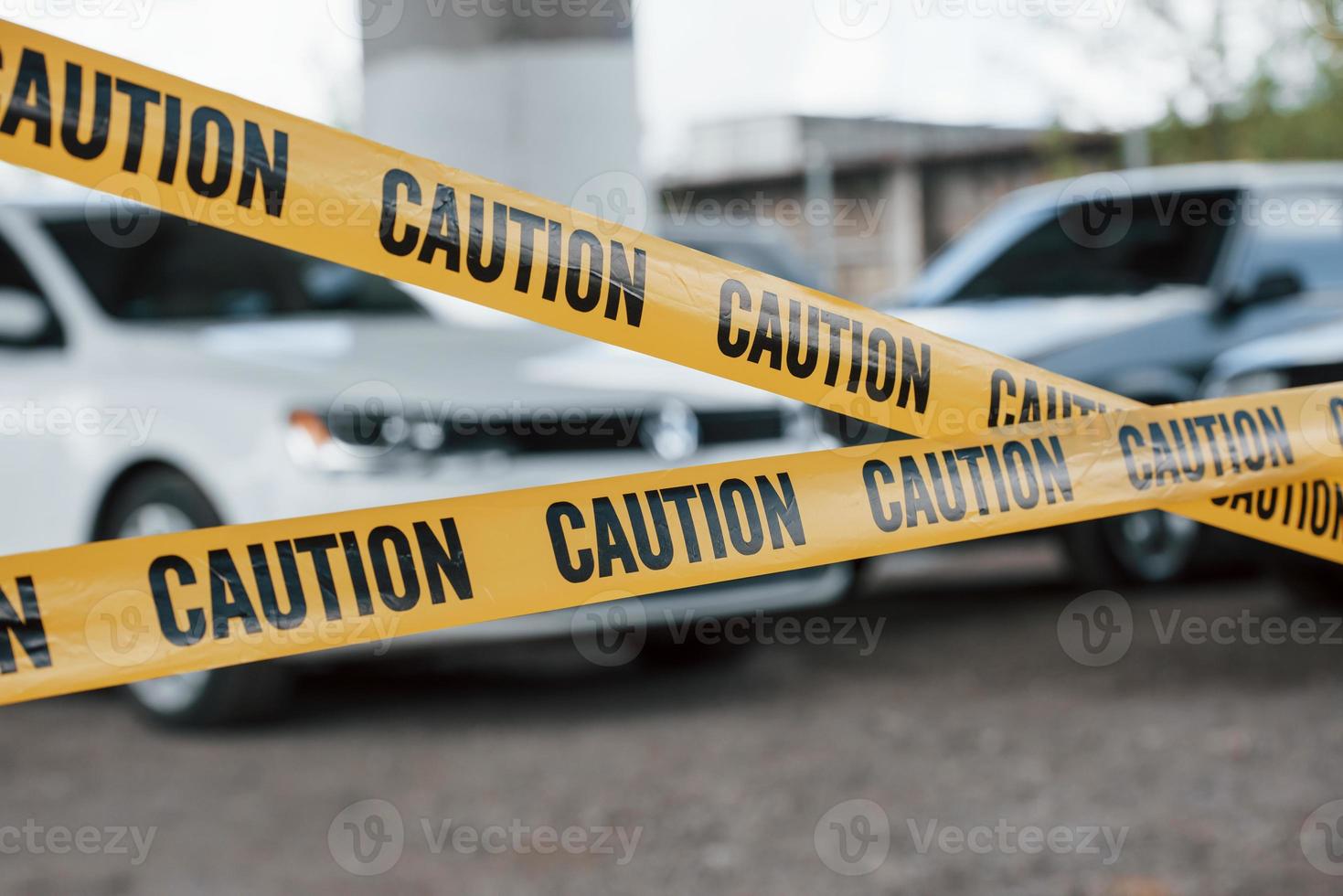 For the safety, do not enter this area. Yellow caution tape near the car parking lot at daytime. Crime scene photo