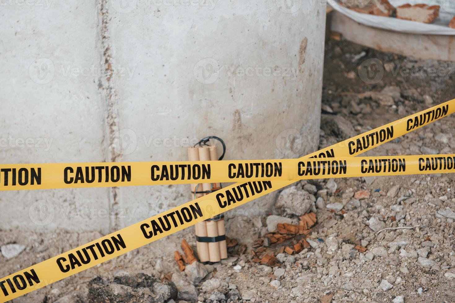There could be catastrophic consequences. Dangerous explosive lying on the ground. Yellow caution tape in front photo