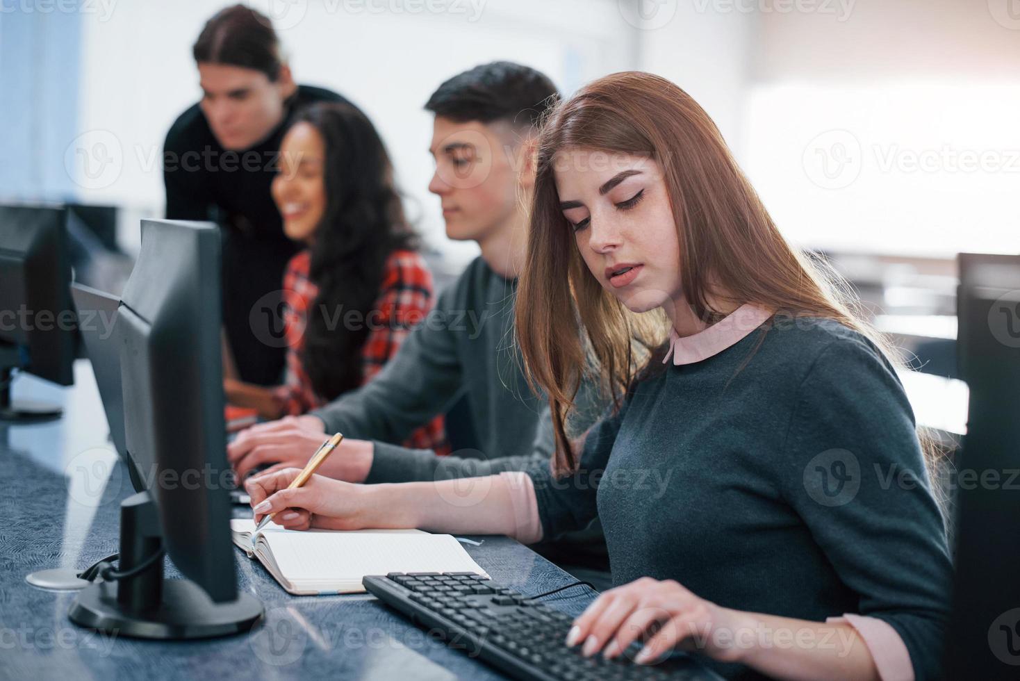 Need to make some calculations. Group of young people in casual clothes working in the modern office photo