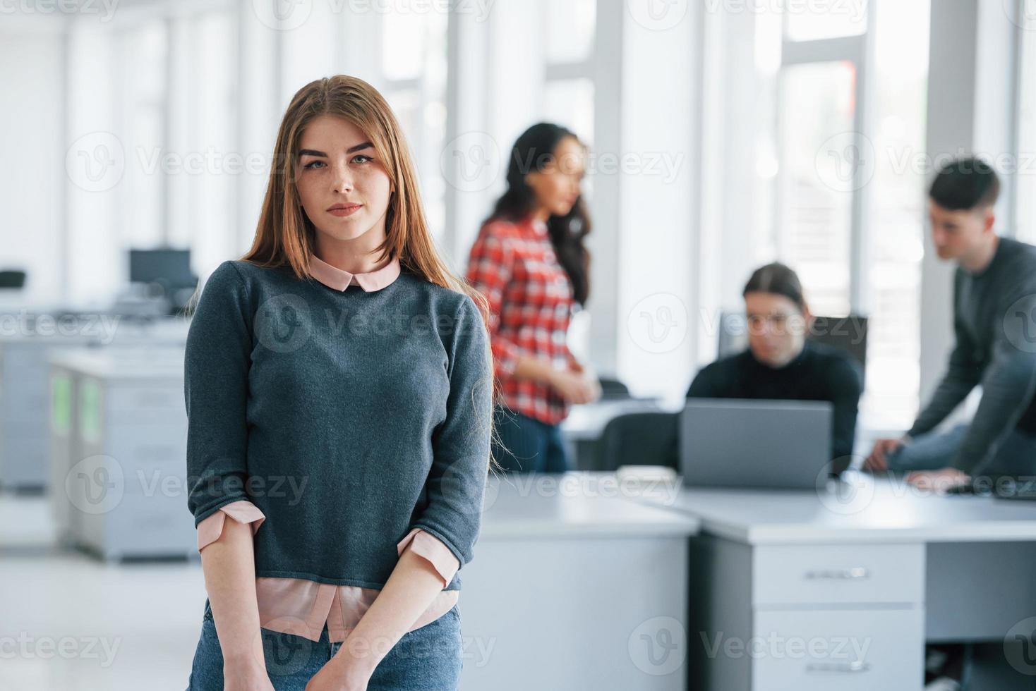 It must be productive day. Group of young people in casual clothes working in the modern office photo