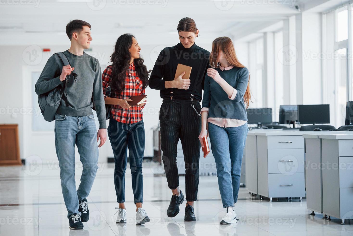 como estuvo tu fin de semana grupo de jóvenes caminando en la oficina en su tiempo de descanso foto