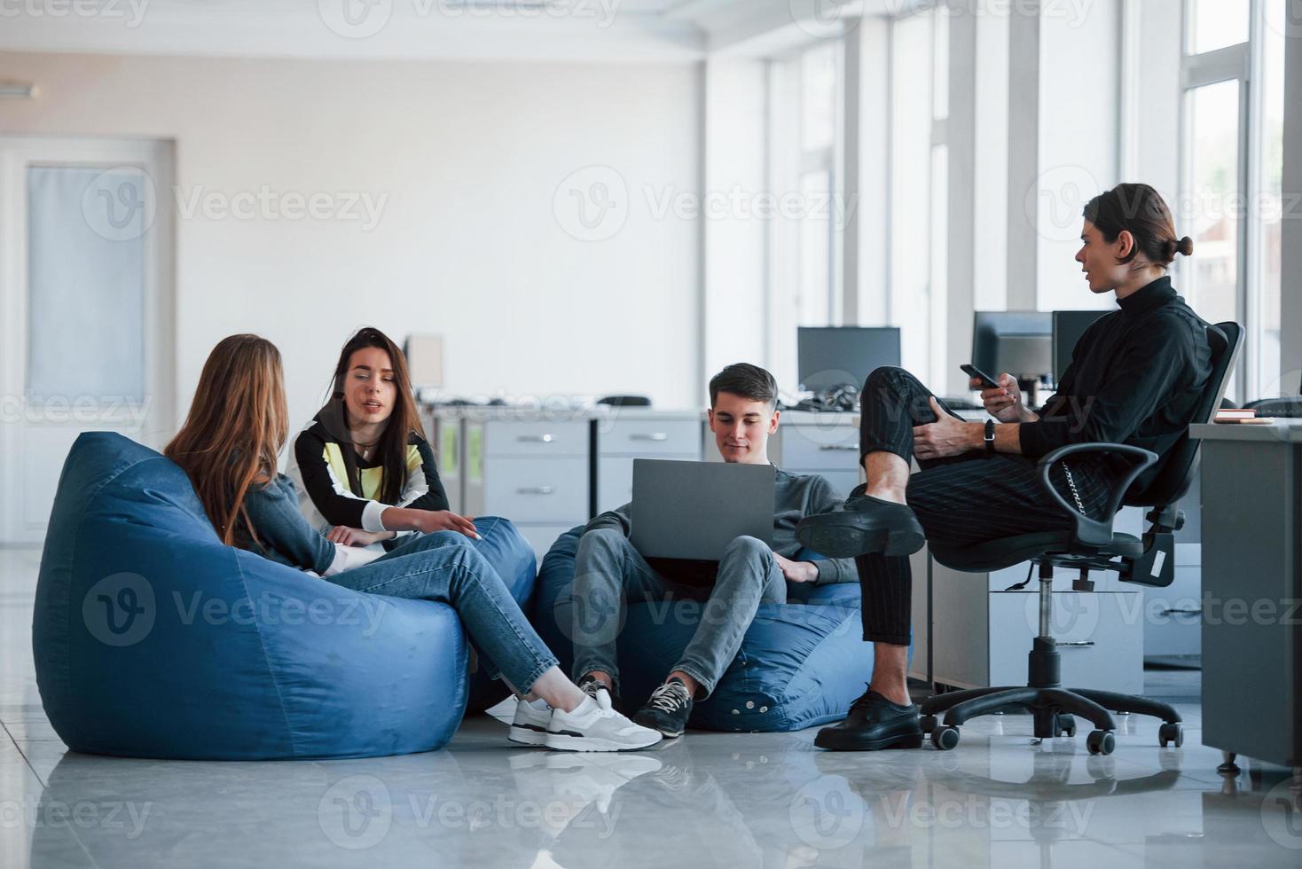 condiciones confortables. grupo de jóvenes con ropa informal trabajando en la oficina moderna foto