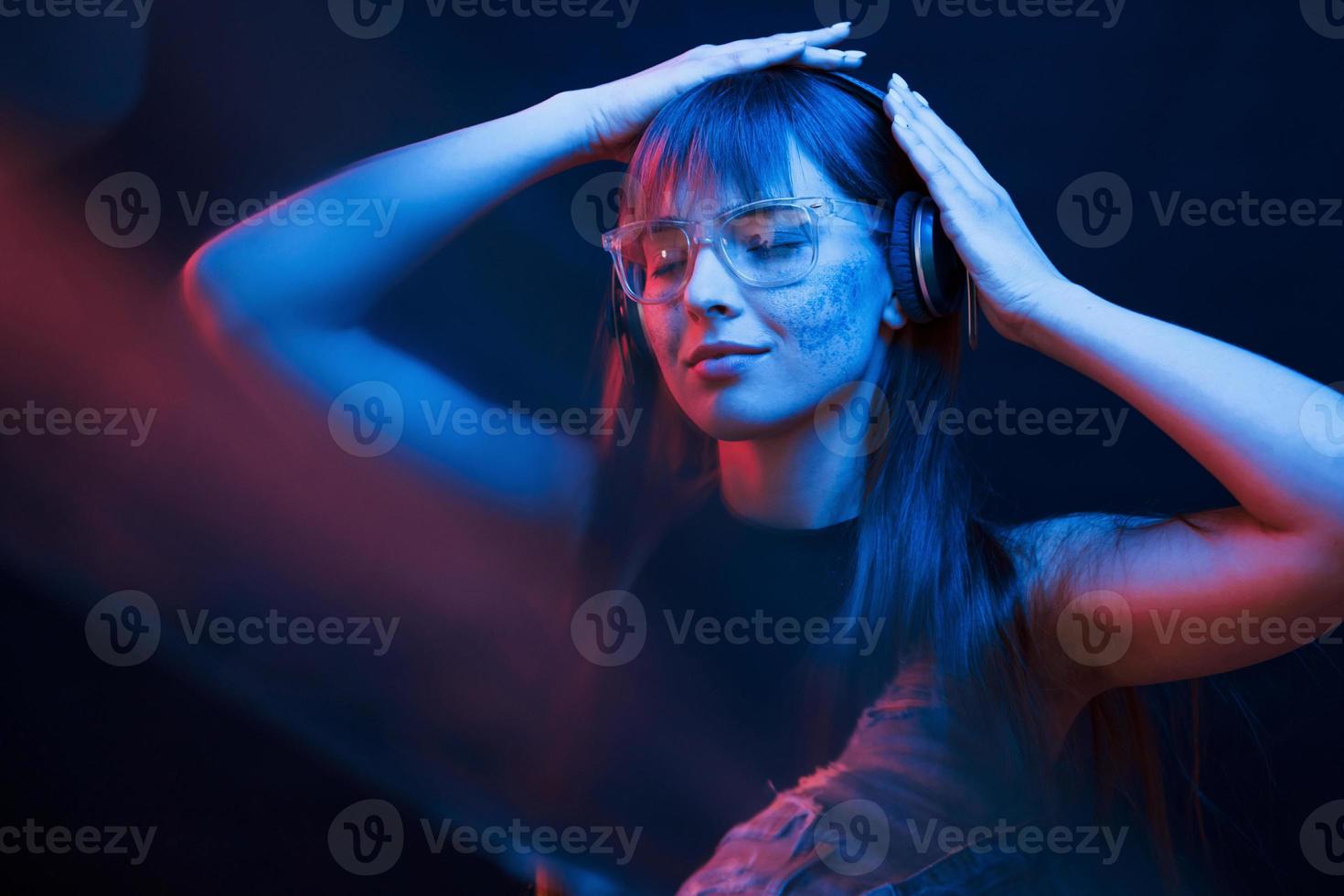 Nice blurring effect. Studio shot in dark studio with neon light. Portrait of young girl photo