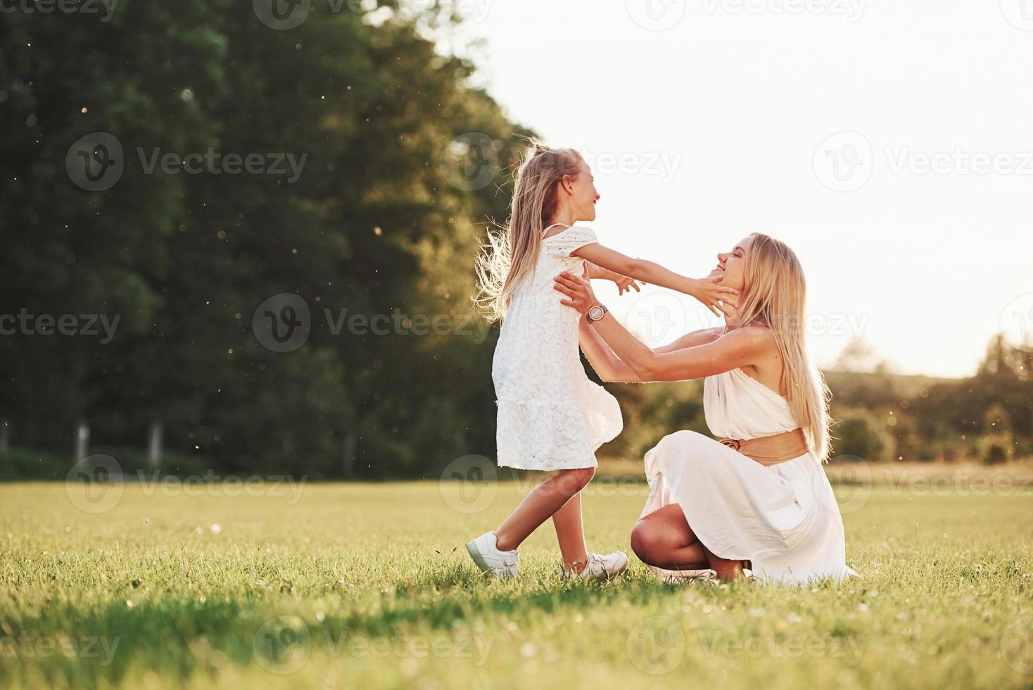 That's so cute. Mother and daughter enjoying weekend together by walking outdoors in the field. Beautiful nature photo