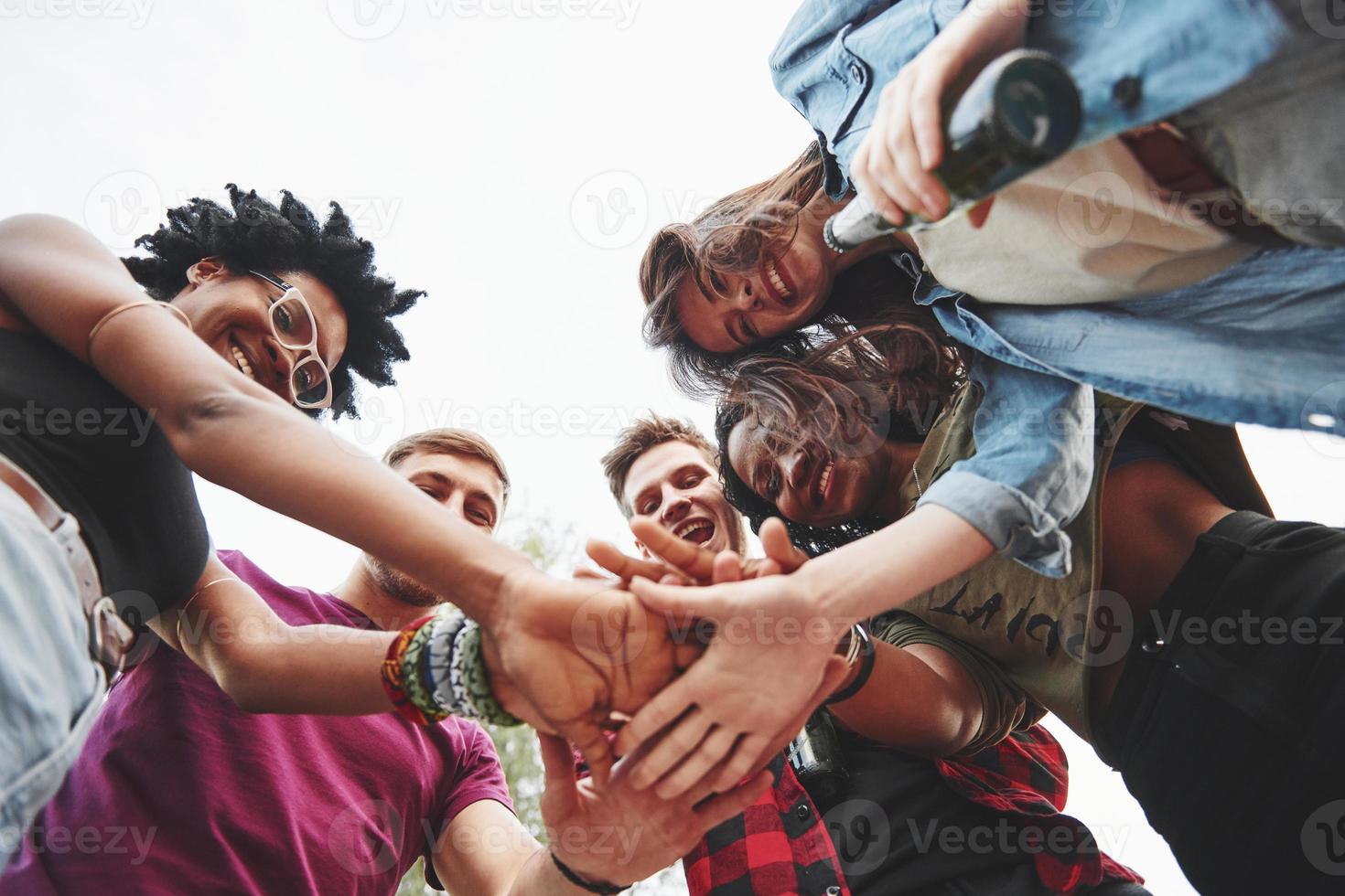 permanecemos unidos. grupo multiétnico de personas tienen fiesta al aire libre. vista desde abajo foto