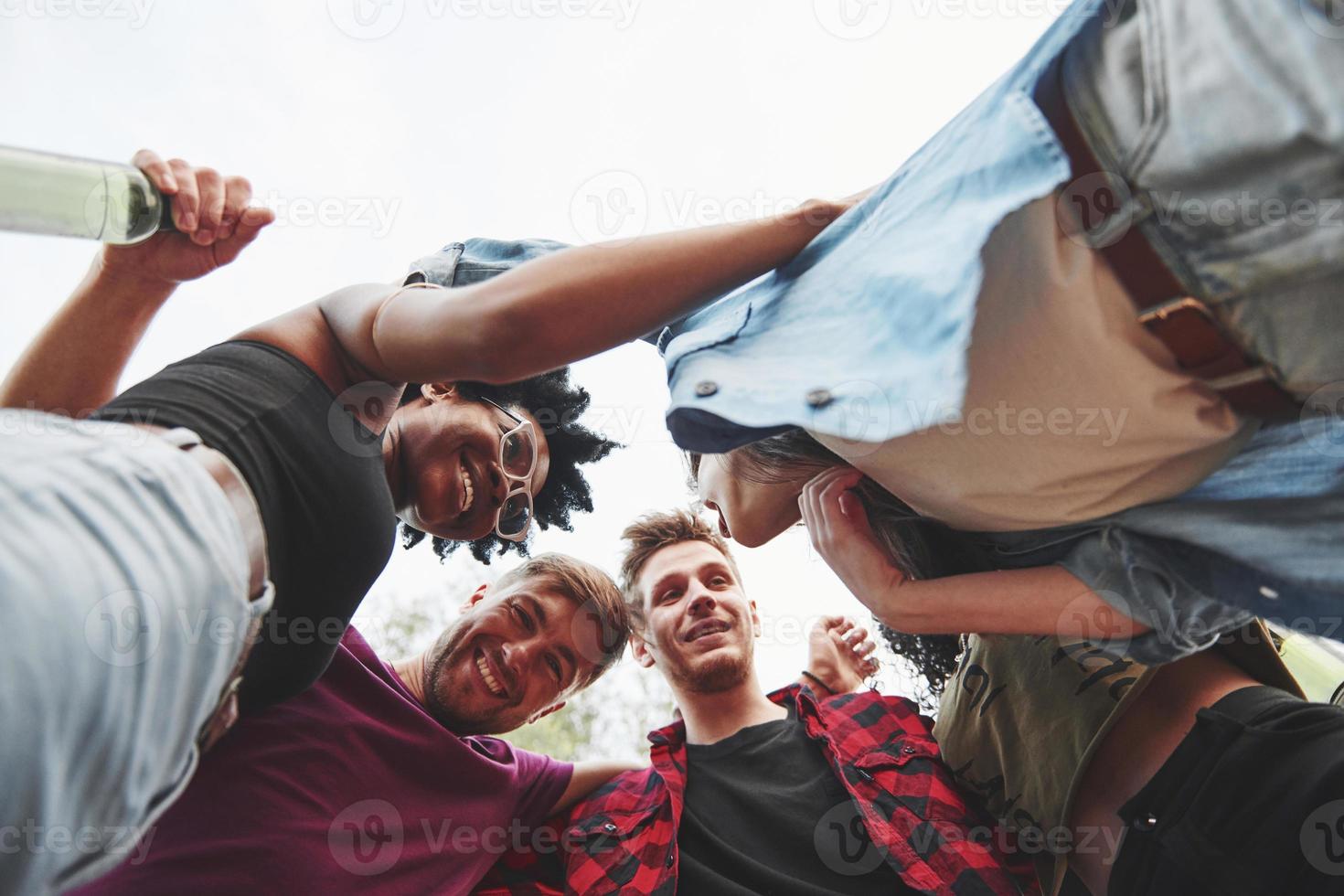 With alcohol. Multi ethnic group of people have party outdoors. View from down photo