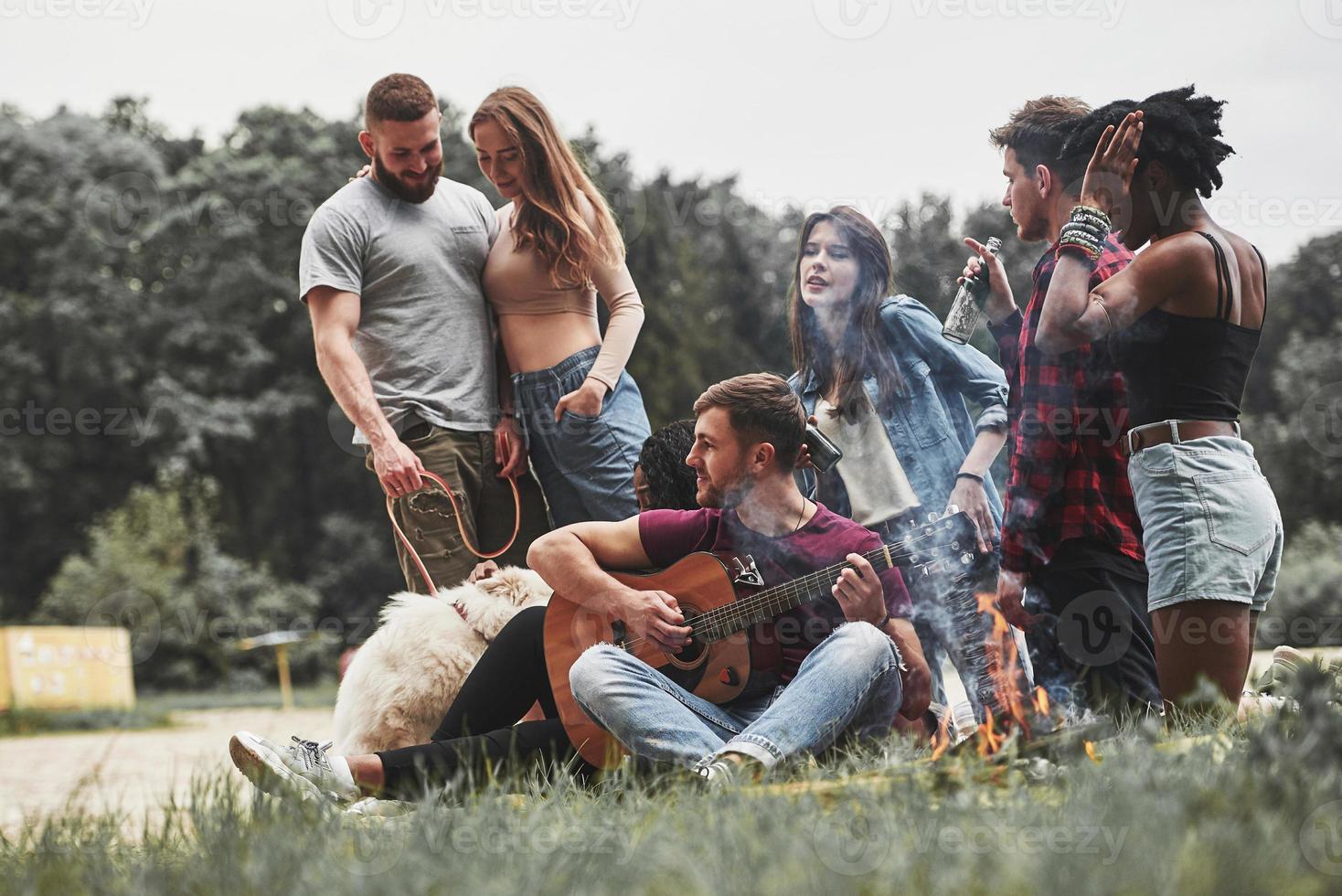 Next to the woods. Group of people have picnic on the beach. Friends have fun at weekend time photo