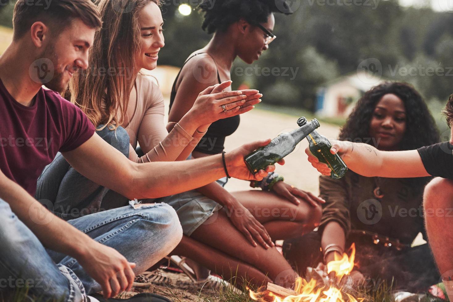 No parties without alcohol for them. Group of people have picnic on the beach. Friends have fun at weekend time photo