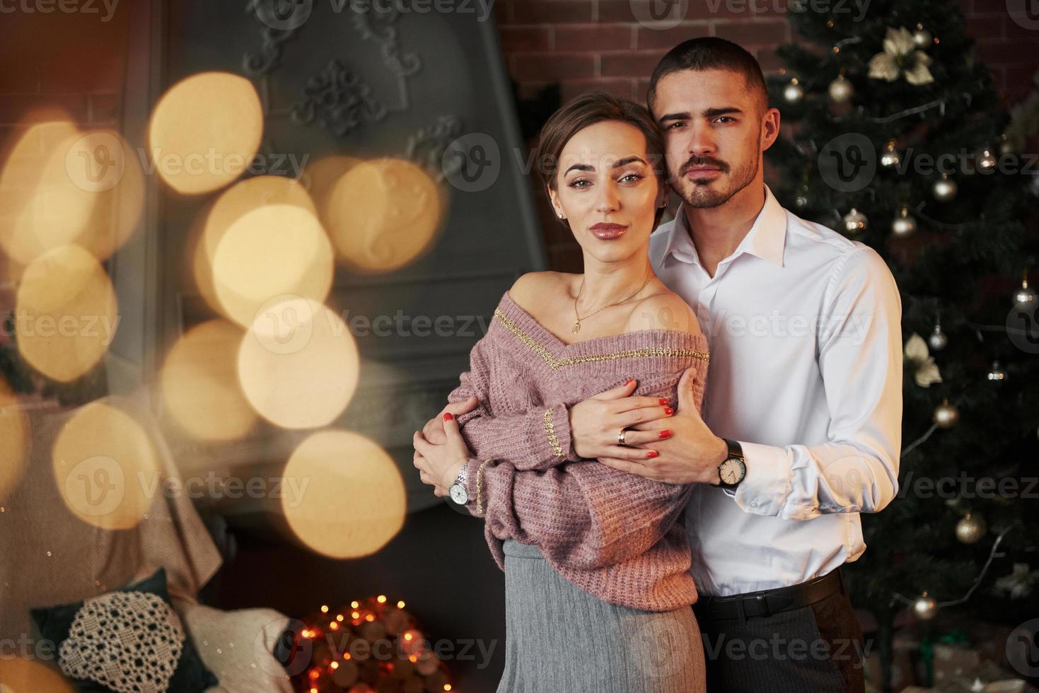 ropa clásica de lujo. linda pareja celebrando el año nuevo frente al árbol  de navidad 15214524 Foto de stock en Vecteezy